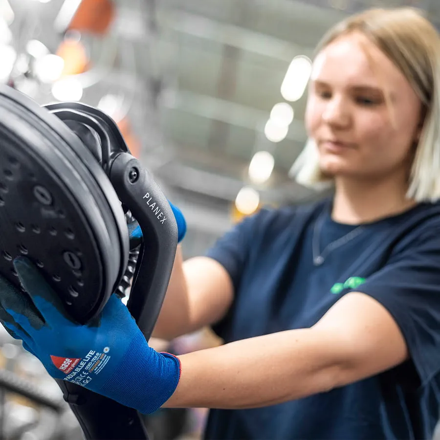 Dans l'usine spacieuse, le personnel assemble les outils électroportatifs sur des postes de travail modernes.  