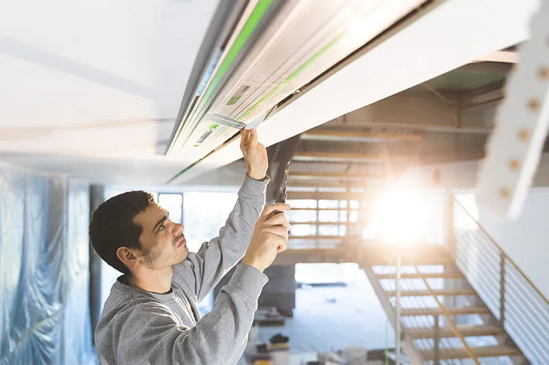Le peintre Stelzle contrôle si les travaux de sciage au plafond ont été correctement exécutés