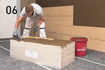 Pour coller les panneaux d'isolation sur toute leur surface, appliquer du PP Fix avec une truelle dentée sur le mur et le panneau.