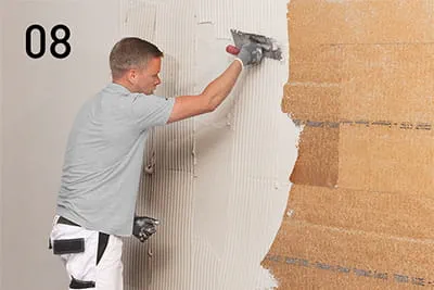 Avec la truelle dentée, enduire de PP Fill toute la surface des panneaux d'isolation fixés au mur.