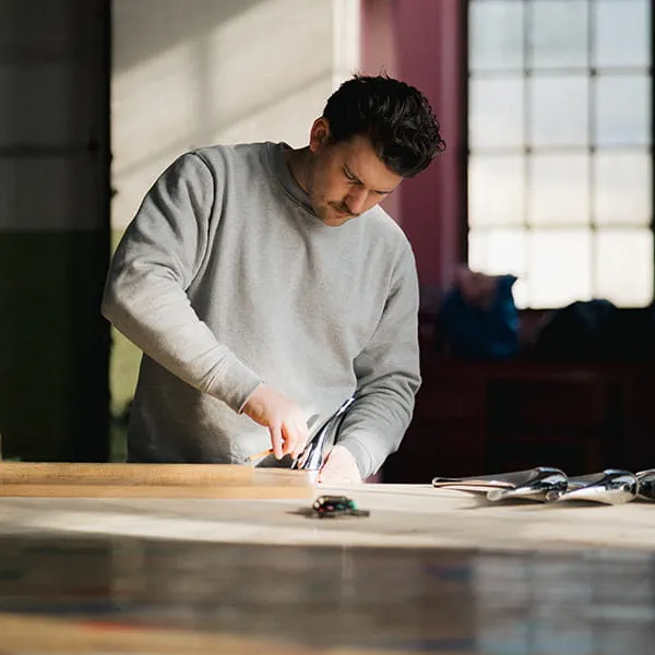 Marius visse les pieds de la table sur le lattis
