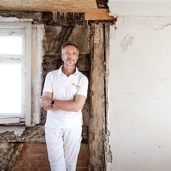 Manfred Schuler, maître artisan peintre et restaurateur, face au mur de la maison à colombages à restaurer