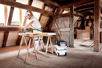 Marco Dworzak remet à neuf les fenêtres et les cadres avec une ponceuse sans fil de Festool, en s'aidant du nouvel aspirateur sans fil CLEANTEC CTLC MINI
