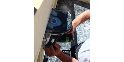 La scie circulaire portative sans fil HKC 55 de Festool sur le chantier d'une maison en bois massif.