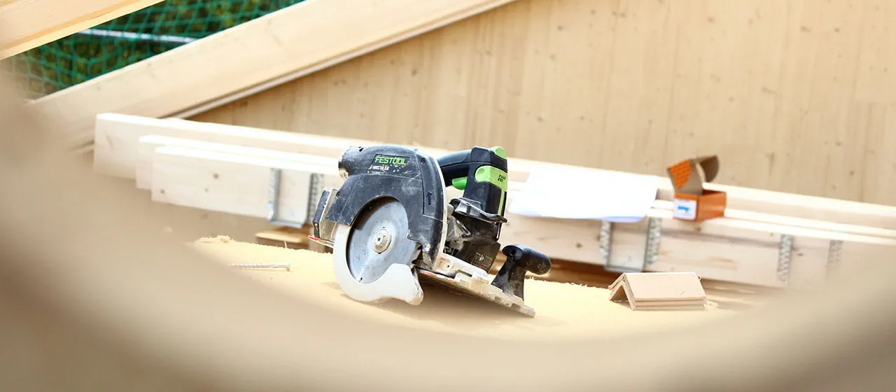 La scie circulaire à capot basculant sans fil HKC 55 de Festool participe au chantier