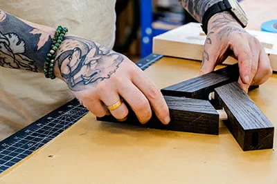 Le maître artisan menuisier Jonas Winkler assemble les baguettes de bois découpées pour former un motif