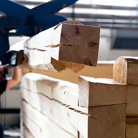 Transport d'une poutre en bois sur site avec une grue.