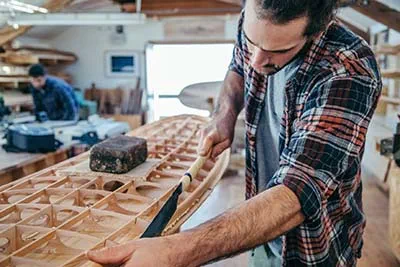 Travaux de ponçage sur une planche de surf