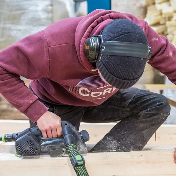 Les poutres de bois sont travaillées avec le rabot à une main Festool