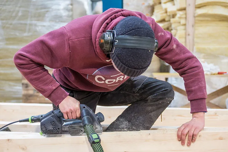 Les poutres de bois sont travaillées avec le rabot à une main Festool